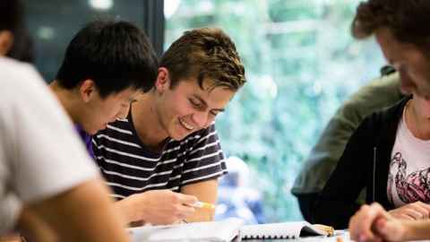 Students around a table reading
